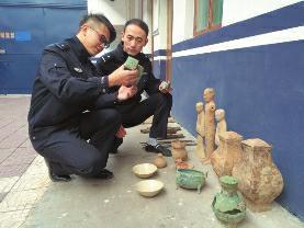 昨日，兴平市公安局刑侦大队东城中队，民警查看被追缴回来的文物 华商报记者 薛望 摄