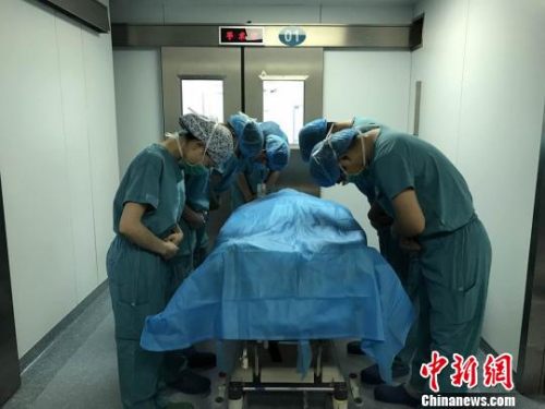 器官摘除手术结束后，医护人员向杨先松的遗体默哀致敬?！±蠲?摄