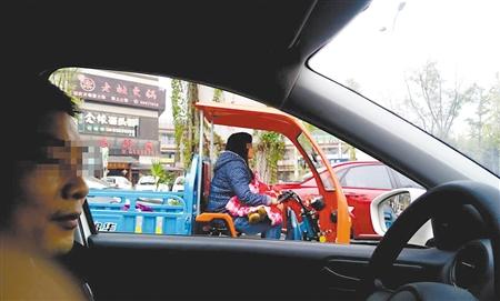 少妇一手抱娃一手开三轮车 被拦下时一脸茫然