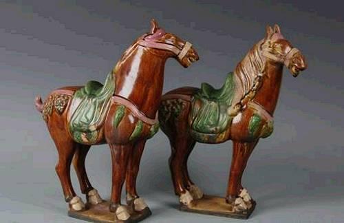 这款“马到成功”开运双件套叫做“唐三彩”，其实是唐代的“冥器”，是唐代用来陪葬的东东。唐代厚葬之风盛行，又不能像秦始皇兵马俑那样摆那么大阵势，就用陶瓷烧出很多马来下葬，让墓主在阴间也有马可骑。