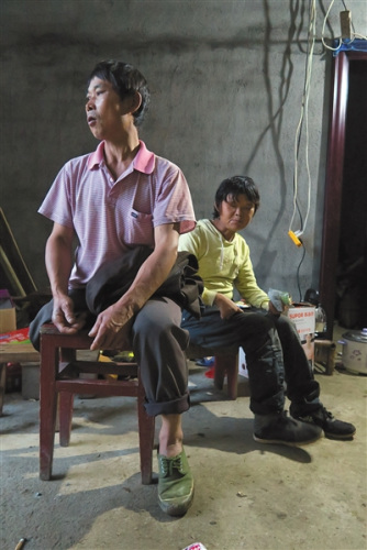 11月20日下午，范家发向来访者介绍自己的家庭情况，身后是他的妻子。