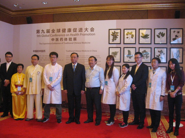 五、王国强与中医药体验展的工作人员留影。 人民政协网记者  张春莉  摄影