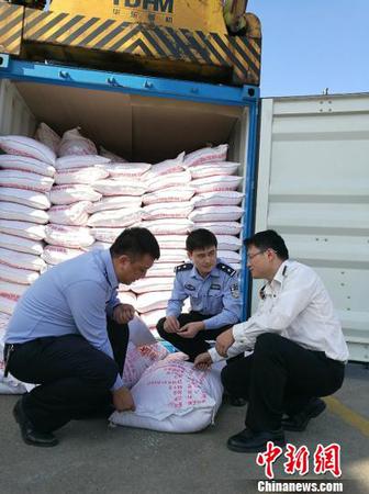 图为海关关员、缉私警察查看涉嫌走私大米 周磊 摄
