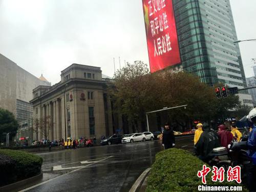 新街口是南京的市中心，现场所有交通信号灯都已变成红灯，往日熙攘热闹的新街口变得静止。车辆缓缓停住，司机自发按响喇叭，主动的鸣笛志哀1分钟；行色匆匆的路人也停下脚步在寒风中低头默哀?！∈⒔?摄