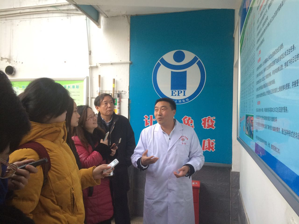 陕西省安康市茨沟镇中心医院院长晏显兴（右）在向记者介绍如何破解农村医疗难题。后排右二为陕西省卫生计生委副主任陈昭。人民政协网记者张春莉  摄