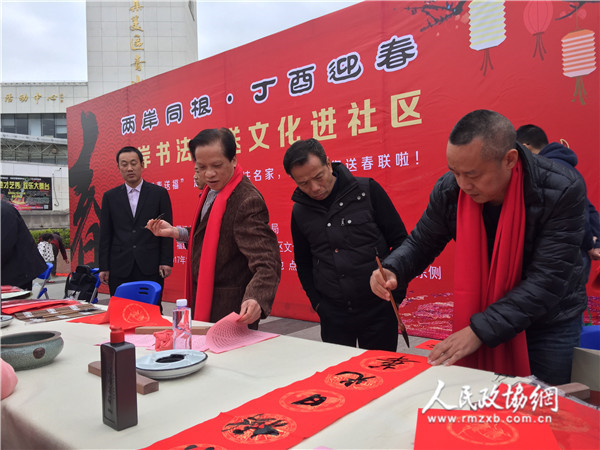 福建省连横书画院院长连明生（右）在书写春联。