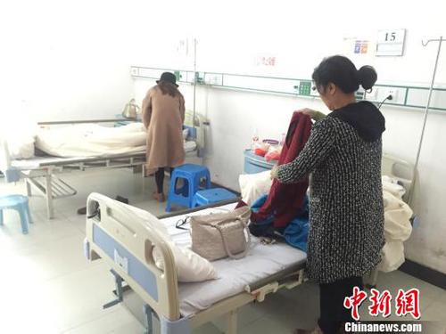 2月12日，谢某母亲在病房内收拾行囊?！〕卵?摄