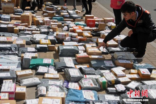 资料图：山西太原一高校外，学生们在地摊上找寻各自的快递。武俊杰 摄