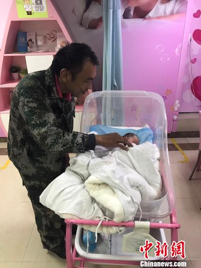 图为张永志与其刚刚诞生的小宝宝在一起 周国亮 摄
