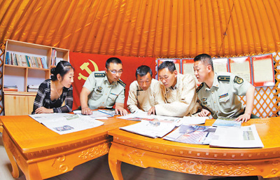 图为边防民警和牧民在“党员中心户”学习党的惠牧政策。