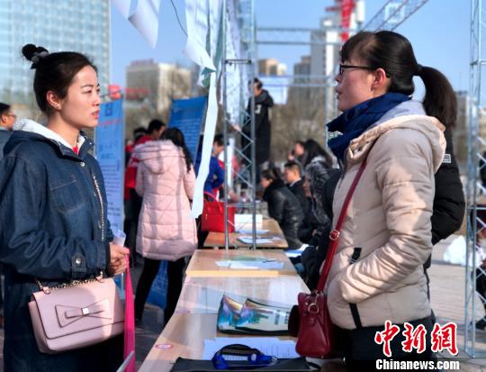 图为一名女大学生拿着自己的简历与用工单位负责人面对面交流，咨询应聘岗位的详细信息?！∷镱?摄