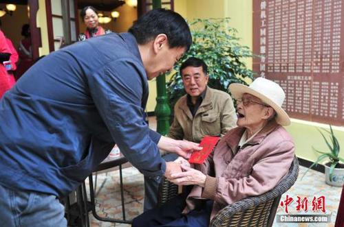 资料图 工作人员向归国华侨送上节日问候。 <a target='_blank' href='http://www.chinanews.com/'>中新社</a>记者 刘冉阳 摄