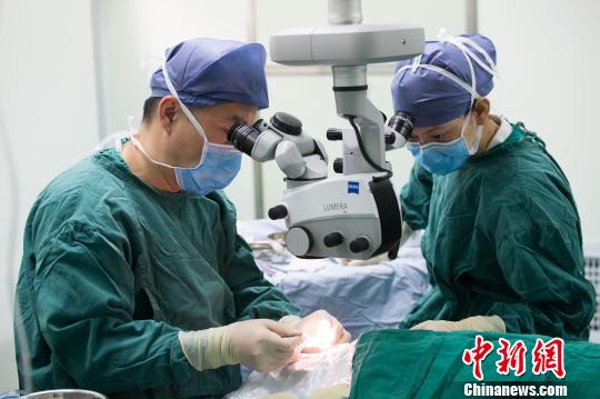 中国中医科学院眼科医院眼科主任医师、教授林涛(左)为留守老人做白内障手术?！±钅闲?摄