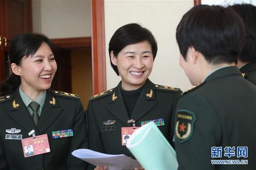 3月7日，全国人大代表刘洋（左二）等在解放军代表团小组会议间隙交流。在两会会场内外，女代表、女委员、女工作人员、女记者在工作中尽职尽责，展现着自己的风采。 新华社记者 李刚 摄