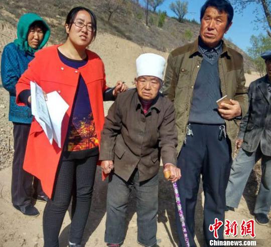 王万芳在贫困户入户调查时，走进演武乡佛岔村马忠玲家和残疾老人在一起。　侯志雄 摄