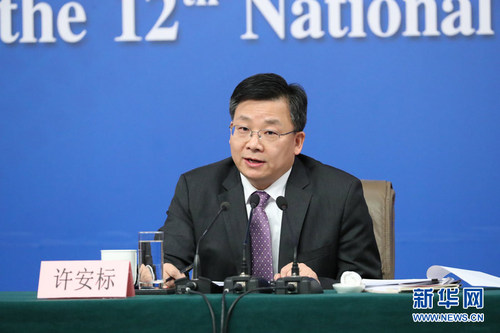 图为全国人大常委会法工委副主任许安标回答记者提问。