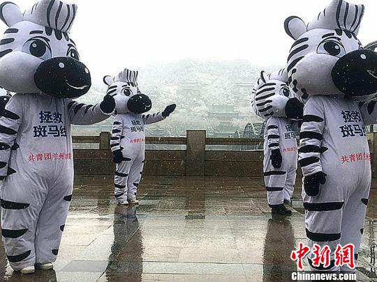 图为伴随着欢快的音乐，多名志愿者化身的“斑马卫士”做着“交通手势操”?！∈肪簿?摄