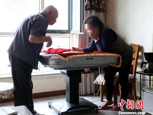图为潘绍斌夫妇正在玩跳棋?！≌藕ｖ?摄