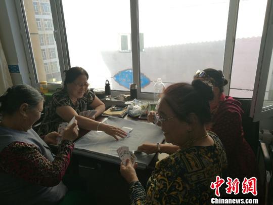 图为进城牧民在一起打扑克?！±畎?摄