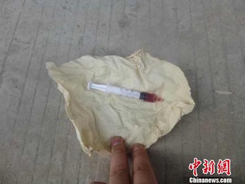 碰瓷者马某每次假装被车辆碰到，后趁机将事先准备好的针管取出，在耳朵里注入红色液体，造成重伤假象。图为警方查获的碰瓷“道具”?！∑呃锖咏痪蠖庸┩?摄