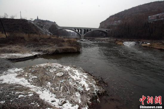 资料图：山西天脊煤化工集团股份有限公司8.7吨苯胺发生泄漏事故，泄漏苯胺随河水流出省外，处于受污河水下游的河北、河南两省也受到影响，三省联动应急，截流治污。截至记者发稿，事故未造成人畜伤亡，山西境内受污染水体苯胺浓度也已大幅下降。事故发生后，当地政府与企业启动应急预案，在排污渠、浊漳河分别进行活性炭吸附处理，并设置5个监测点实时监测水质。图为排污渠与浊漳河交汇口河边随处可见除污所用的石灰。张云 摄