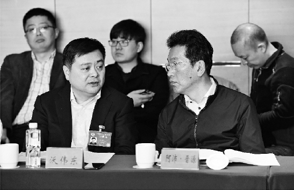 今年两会期间，阿沛·晋源（右）在界别小组讨论会上。    本报记者  齐波  摄