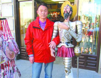  图片说明：谢厚平在西班牙一工艺品店门口与堂吉柯德卡通形象合影