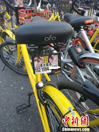 一辆共享单车上的小广告。<a target='_blank' href='http://www.chinanews.com/' >中新网</a>记者 李金磊 摄