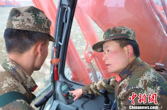 武警交通第二支队四大队达东村训练基地挖掘机二班班长张凯华(右)手把手教学员操作细节 郭江宸 摄