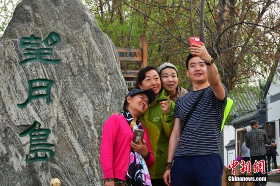 4月3日下午，河北安新县“华北明珠”白洋淀游人如织，图为北京游客拍照留影。<a target='_blank' href='http://www.chinanews.com/'>中新社</a>记者 翟羽佳 摄