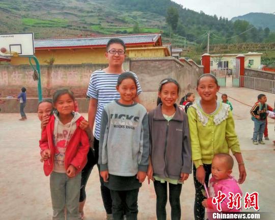 图为杨早龙和大凉山的孩子们在一起?！∈芊谜吖┩?摄