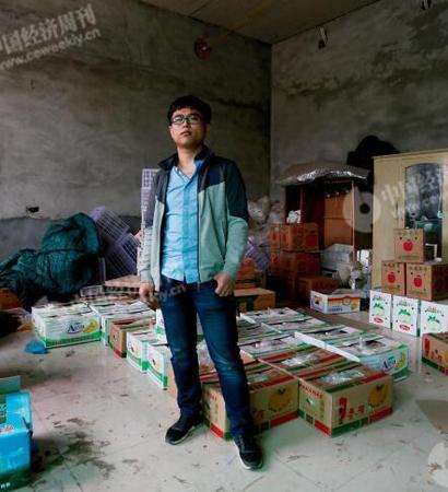 p29-1 程新在自己家中。他的父母在镇上贩卖水果，家中一间暂未装修的房内堆满各种水果。