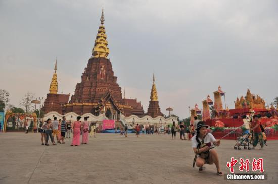 4月13日，云南西双版纳“告庄西双景”内，在金塔前留影的游客?！案孀魉啊蔽鲇铮馕熬潘?，位于澜沧江畔，占地1200亩的景区内傣式风格浓郁。自2012年开业至今，年接待游客量已经突破400万人次，2015年春节期间，日均游客人数突破10万人次，成为云南旅游新地标。 <a target='_blank' href='http://www.chinanews.com/'>中新社</a>记者 任东 摄