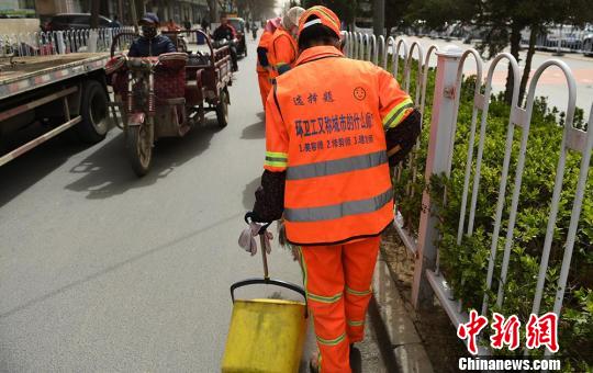 马甲的背部采用“一个问题，三个选项”的形式，环卫工穿上它便成为寓教于乐为一体的“行走的考卷”，并且这30余道选择题都是他们集思广益想出来的?！⊙钛廾?摄