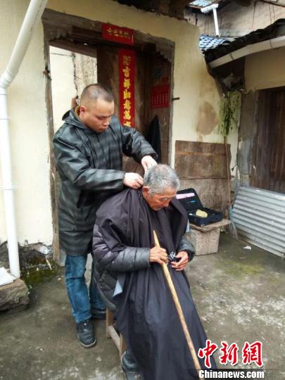 金世富进山为老人理发 已经坚持八年。