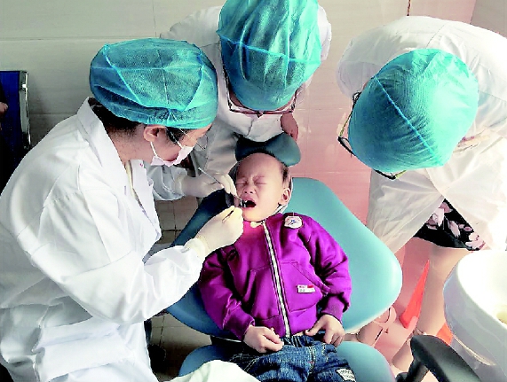 牛忠英委员（左一）在义诊中。    本报记者  蔡鎏  摄