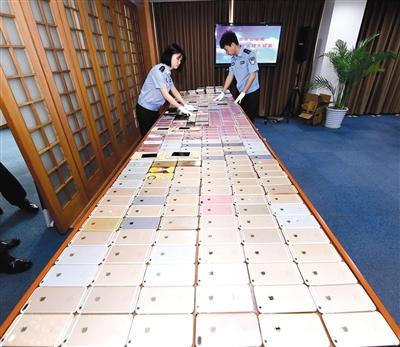 北京警方破获特大盗销手机团伙，起获的525部被盗手机铺满了一张大桌子，其中大多是苹果手机。	警方供图