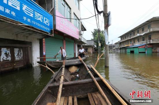 资料图：2016年7月14日，江西省都昌县汪墩乡排门村、秤钩湾村遭受洪涝灾害，村民靠船只出行。杨帆 摄
