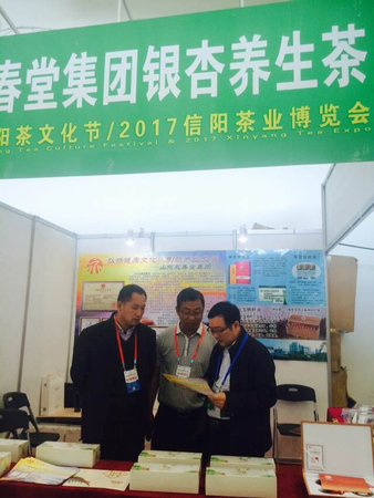 5、来自全国各地的茶商积极参加第25届信阳茶文化节展览展示。图为来自山东省济宁市永春集团的参展商在研究推展措施。  梓涵  摄影