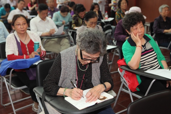 老人们在认真记笔记。