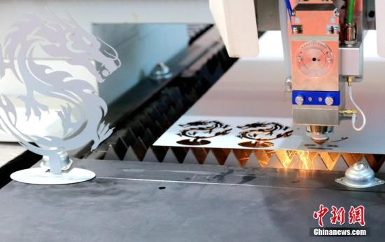 一激光机床正在精准切割“龙”形造型。 <a target='_blank' href='http://www.chinanews.com/'>中新社</a>记者 王舒 摄