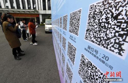 资料图：一些求职者在招聘会现场扫二维码查询工作岗位。 张斌 摄 (图文无关)