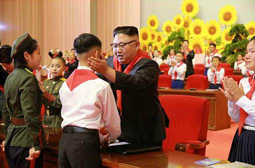 金正恩佩戴红领巾与儿童互动。