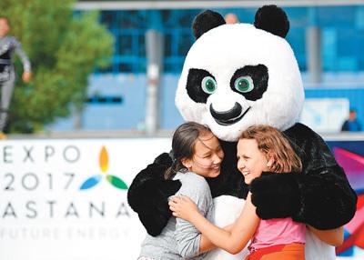 中国侨网图为5日，当地儿童与舞蹈团中代表中国元素的熊猫卡通形象互动。  　　新华社记者  吴晓凌摄