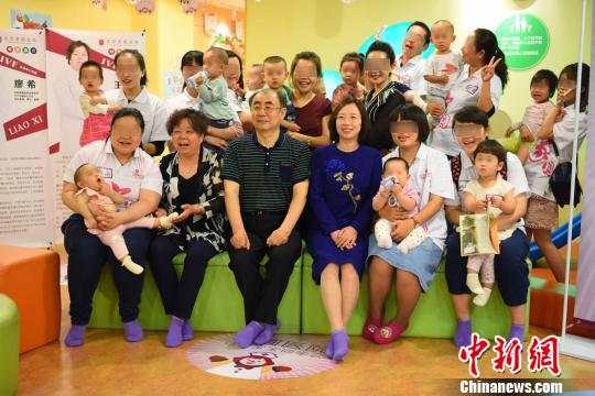 图为6日部分“试管宝宝”及父母与当年培育他们的医生和专家合影。　徐兆华 摄
