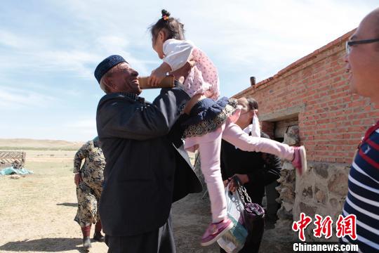 图为张义兵的阿爸将汉族孙女高高举起。　樊晓丽 摄