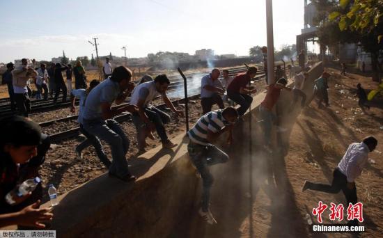 当地时间9月26日，土耳其Suruc，在叙利亚与土耳其边境再次发生动乱。大批叙利亚境内的库尔德难民及士兵在土耳其库尔德人的帮助下，拆毁两国国境之间的隔离墙强行进入土耳其。