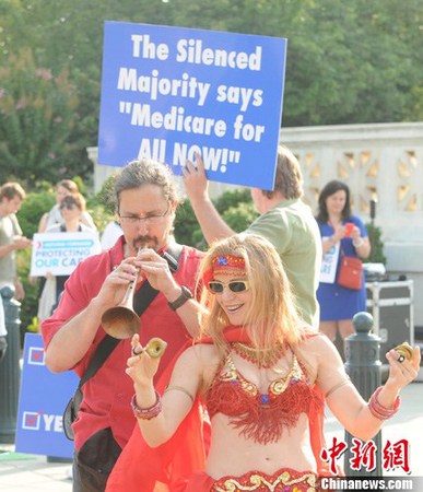 华盛顿时间6月28日上午，美国最高法院裁决奥巴马两年前签署的医改法案核心内容不违宪法。法庭意见书正式公布前，法案支持者聚集在最高法院门前，载歌载舞为法案造势。<a target='_blank' href='http://www.chinanews.com/'>中新社</a>发 德永健 摄