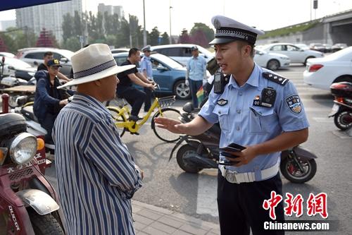 6月21日上午，北京交警敖翔正在处理交通违法行为。<a target='_blank' href='http://www.chinanews.com/' >中新网</a>记者 金硕 摄