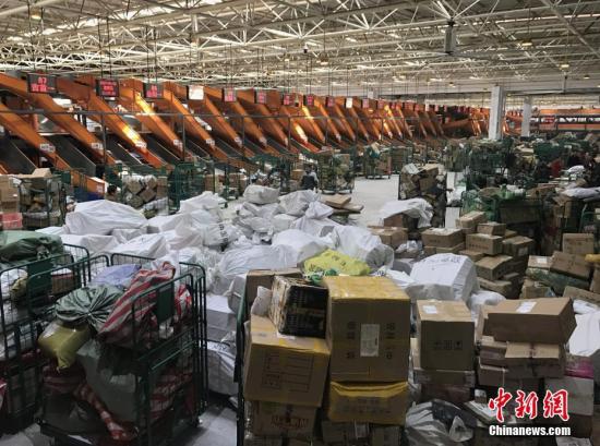1月20日，湖南长沙邮区中心局的工作人员正在处理堆积的快递包裹。随着中国春节的临近，为了避开实体店购物的拥挤和繁琐，越来越多的人选择网络购置年货，快递行业也随之迎来“春运”高峰。<a target='_blank' href='http://www.chinanews.com/'>中新社</a>记者 唐小晴 摄
